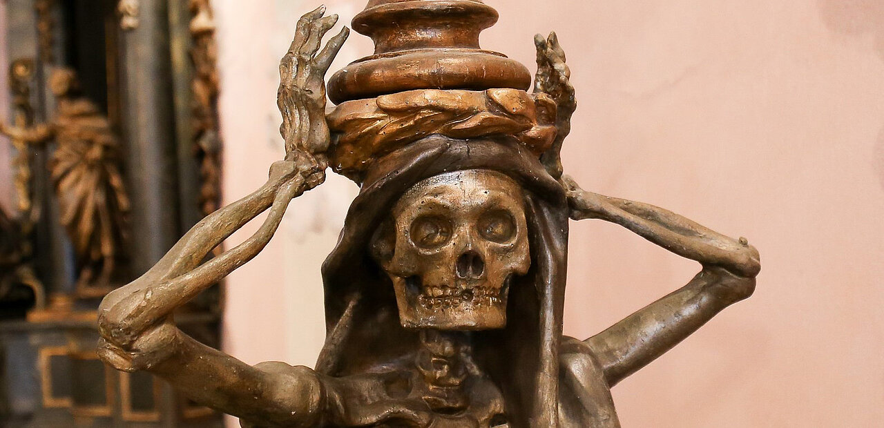 Der Schädel oder Tod dient als Mahnung daran, das irdische Leben in Demut zu führen: "Bedenke, dass du sterben musst" (lat. "Memento mori").