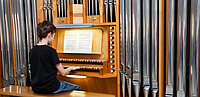 Junge sitzt an Orgel