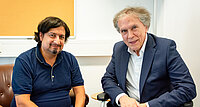 Stefan Hauser im Gespräch mit Botschafter Emil Brix. Aufgrund einer Erkrankung ist der Rollstuhl ein wichtiges Fortbewegungsmittel.