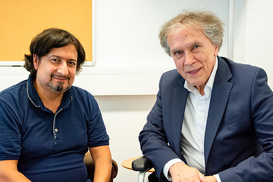 Stefan Hauser im Gespräch mit Botschafter Emil Brix. Aufgrund einer Erkrankung ist der Rollstuhl ein wichtiges Fortbewegungsmittel.