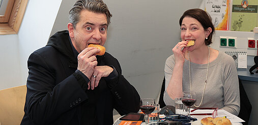 Christoph Wagner-Trenkwitz und Sophie Lauringer essen Sesamringe.
