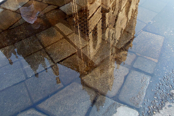Chor der Zuversicht: Der Dom spiegelt sich in vielem wider – Sonnenschein nach einem heftigen Regen.