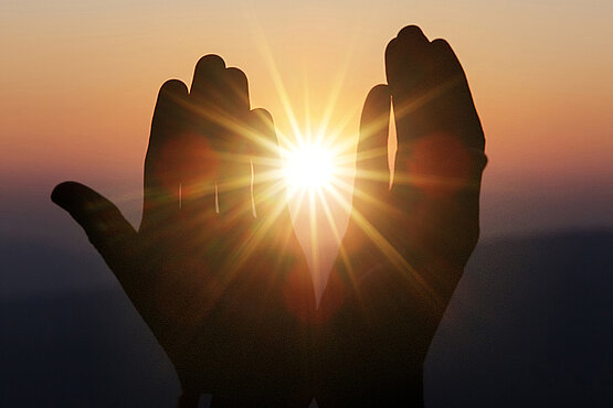 Zwei Hände im Sonnenlicht.