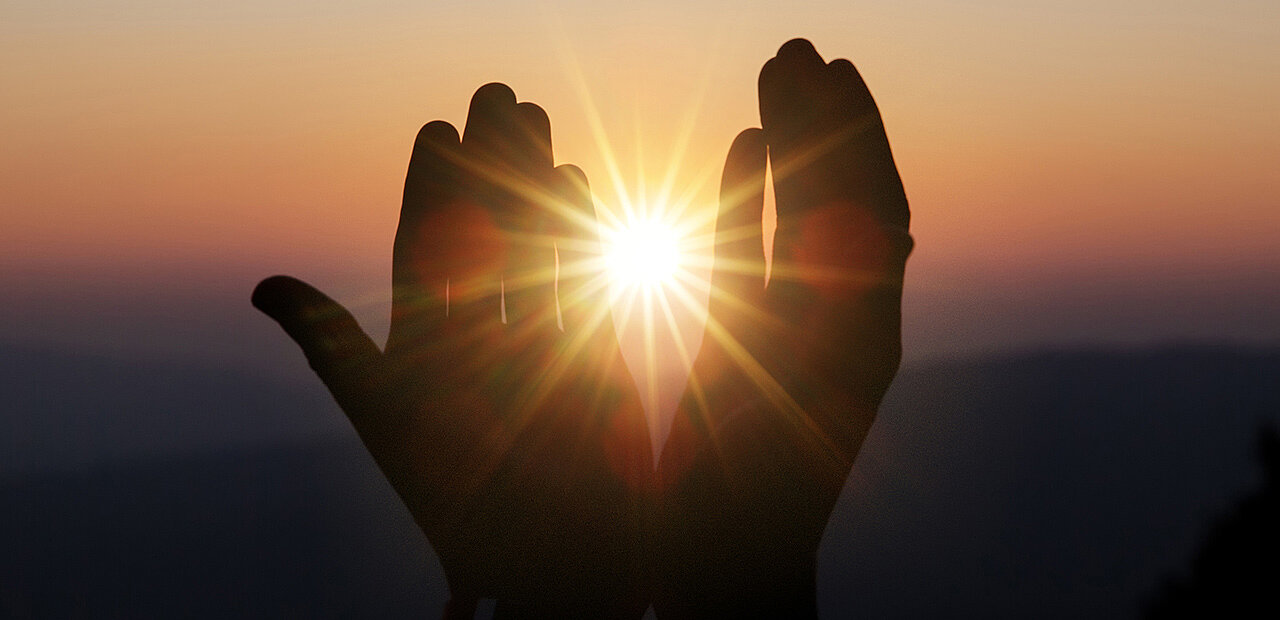 Zwei Hände im Sonnenlicht.