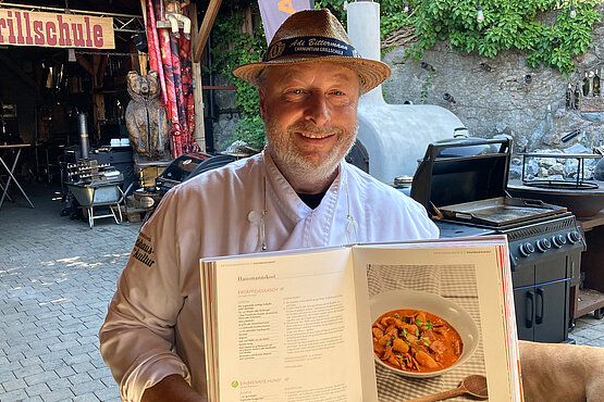 Grillmeister Adi Bittermann mit einem seiner Kochbücher. Der Kochprofi verrät im Podcast das Geheimnis eines guten Steaks. 