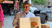Grillmeister Adi Bittermann mit einem seiner Kochbücher. Der Kochprofi verrät im Podcast das Geheimnis eines guten Steaks. 
