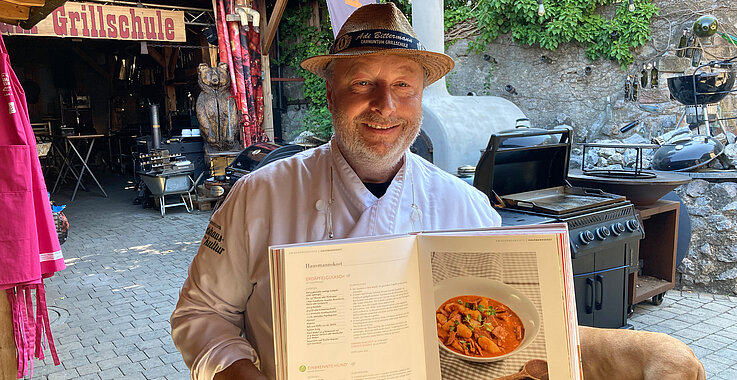 Grillmeister Adi Bittermann mit einem seiner Kochbücher. Der Kochprofi verrät im Podcast das Geheimnis eines guten Steaks. 