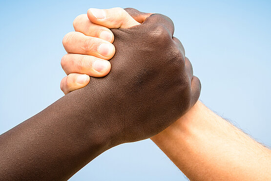 Schwarze und weiße Hand beim Händeschütteln