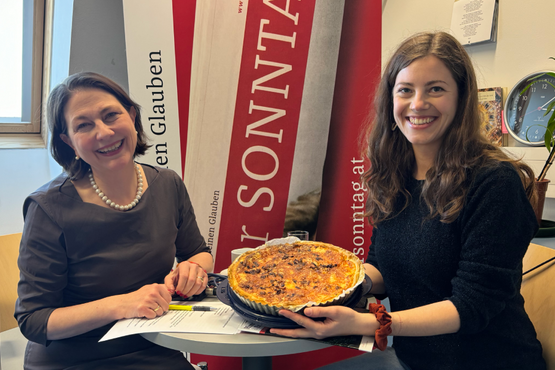 Sophie Lauringer mit Ines Schaberger in der Redaktion. Die beiden halten eine Käsewähe.