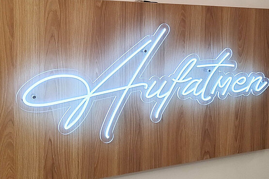 „Aufatmen“ – die große Leuchtschrift im Eingangsbereich ist das Erste, was einem ins Auge fällt, wenn man Tageshospiz Aumannplatz betritt.