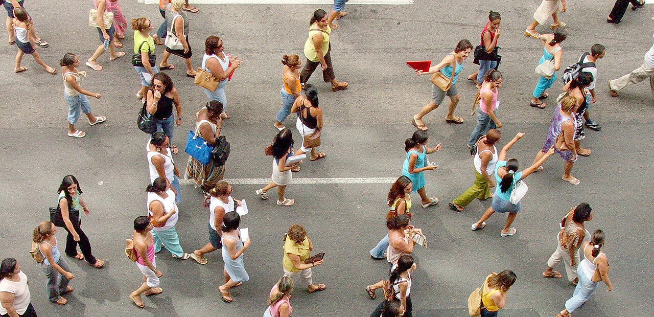 Eine Menschenmenge geht auf der Straße, fotografiert von oben.