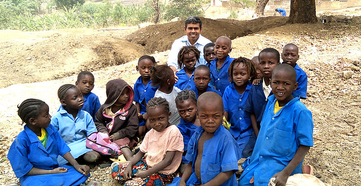 Pater Sen Vellakada mit afrikanischen Kindern