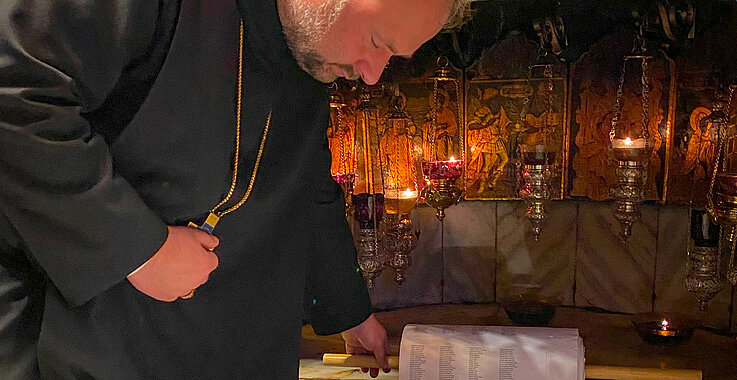 Gebet in der Geburtstgrotte: Abt Nikodemus entrollt die Liste der Namen, die nach  Bethlehem getragen wurden.