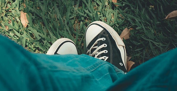 Ein Teenager in Jeans und Turnschuhen. 