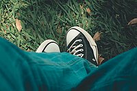 Ein Teenager in Jeans und Turnschuhen. 