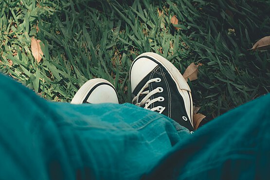 Ein Teenager in Jeans und Turnschuhen. 