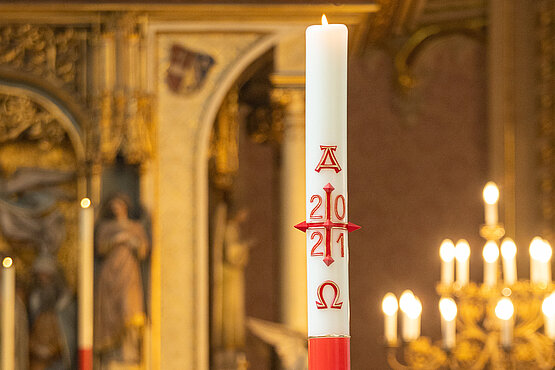 Die Osterkerze wird in der Osternacht an dem meist vor der Kirche entfachten Feuer entzündet und  danach in die dunkle Kirche getragen. 