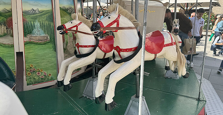 Zwei Pferde eines Karussells sind zu sehen. 