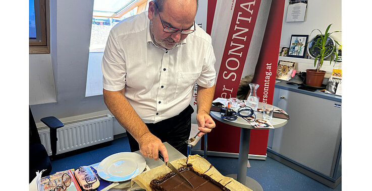 Schokolade pur: Diakon Mayr schneidet den Kuchen an. 