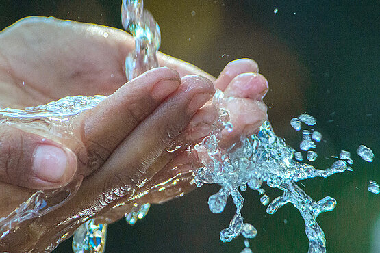 Hände, die, zu einer Schale geformt, frisches Wasser aufnehmen