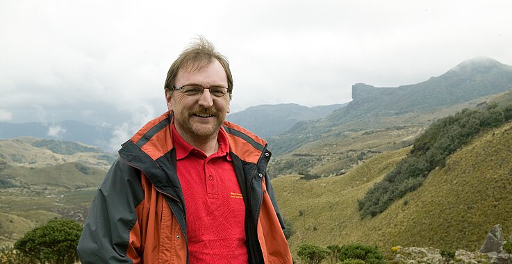 Reinhard Heiserer auf einem Berg, im Hintergrund die Landschaft Ecuadors.