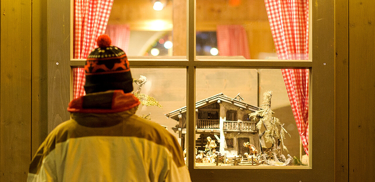 Mann sieht sich Krippe im Schaufenster an