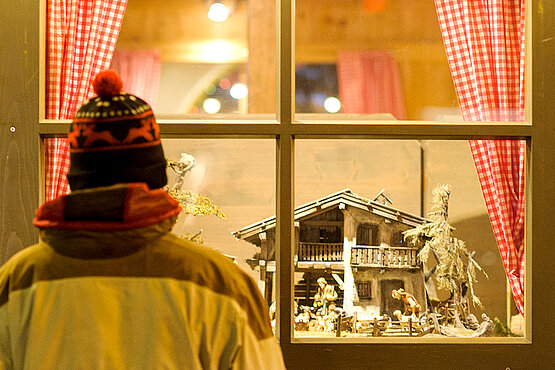 Mann sieht sich Krippe im Schaufenster an