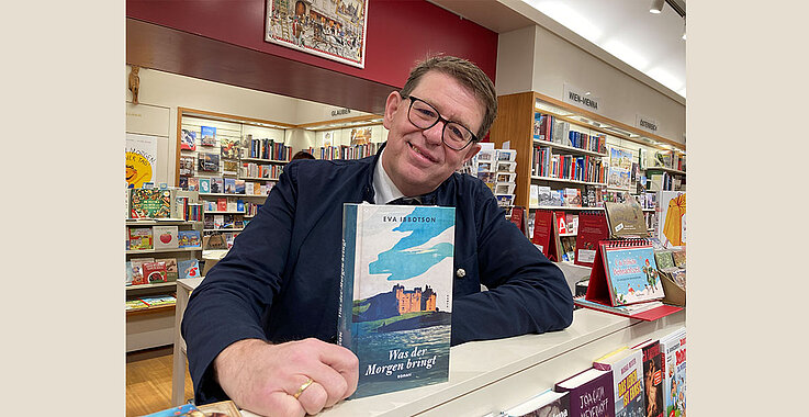 Buchhändler Werner Riedmüller und der Roman "Was der Morgen bringt."