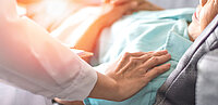 Arzt legt Hand auf Schulter von kranker Person