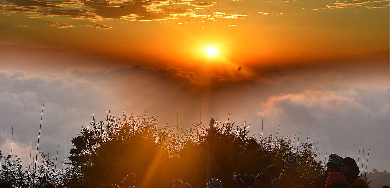 Menschen beobachten einen Sonnenuntergang