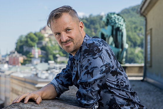 Philipp Hochmair (52) studierte Schauspiel am Max-Reinhardt-Seminar. Er ist seit 2013 solistisch als Jedermann Reloaded und seit 2024 Jedermann bei den Salzburger Festspielen zu sehen. 