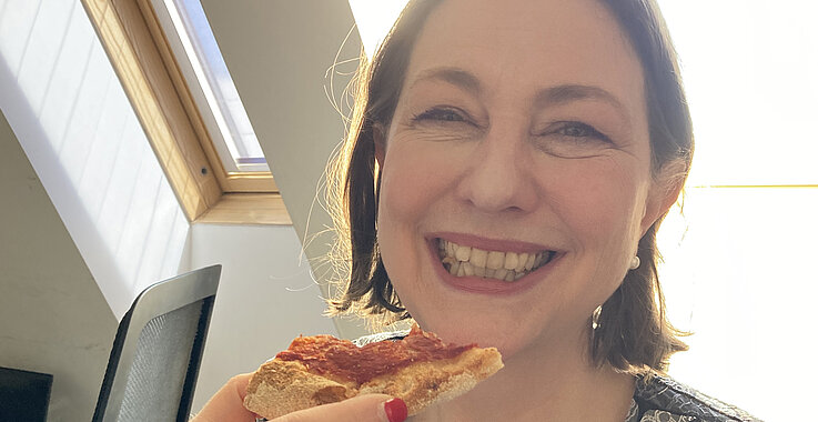 Sophie Lauringer mit einem Stück Pinsa in der Hand.