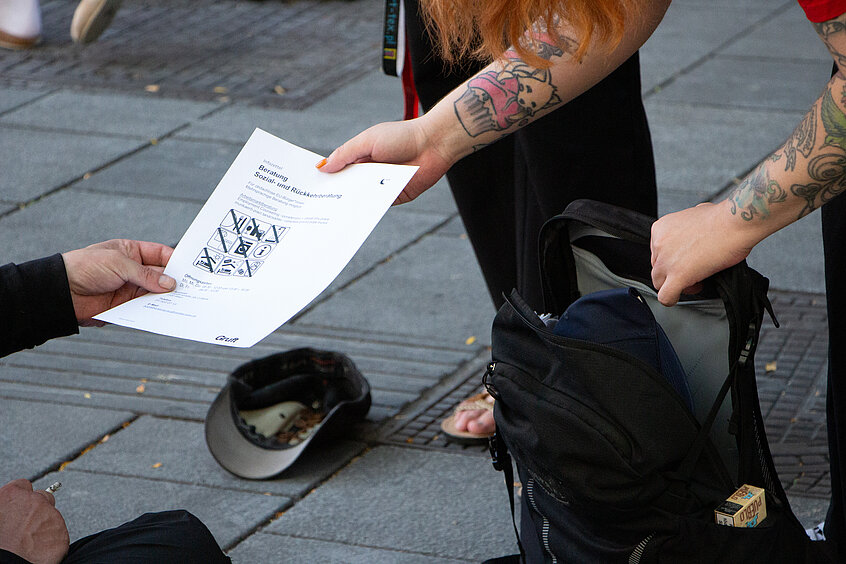 Die Sozialarbeiterinnen teilen auch immer wieder Infozetteln mit wichtigen Informationen für obdachlose Menschen, Angeboten der Gruft oder zu kühlen Orten in der Stadt aus. 