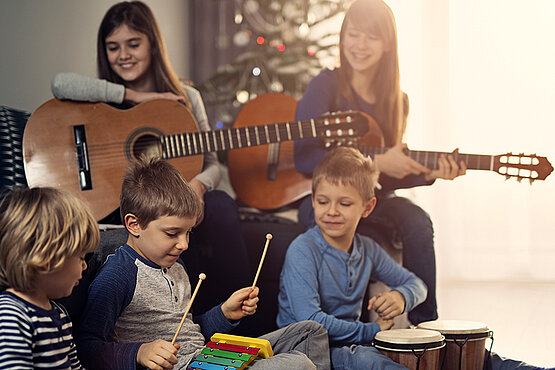 musizierende Kinder vor Christbaum
