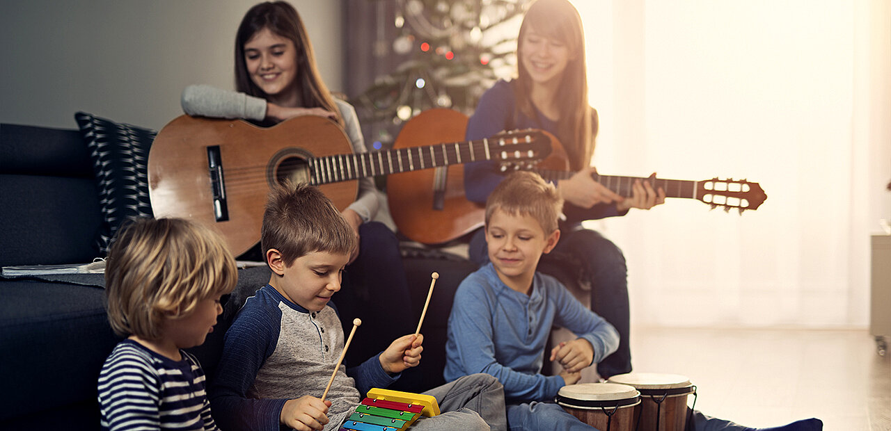 musizierende Kinder vor Christbaum