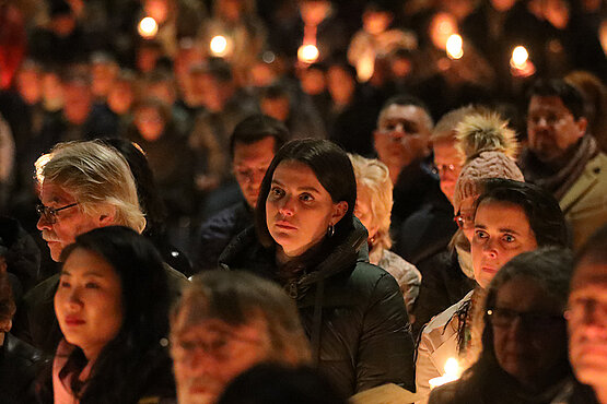 Menschenmenge in einer Kirche am Abend.