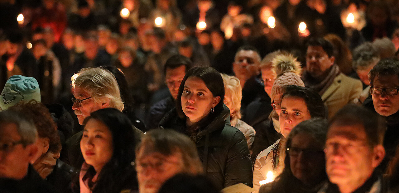 Menschenmenge in einer Kirche am Abend.