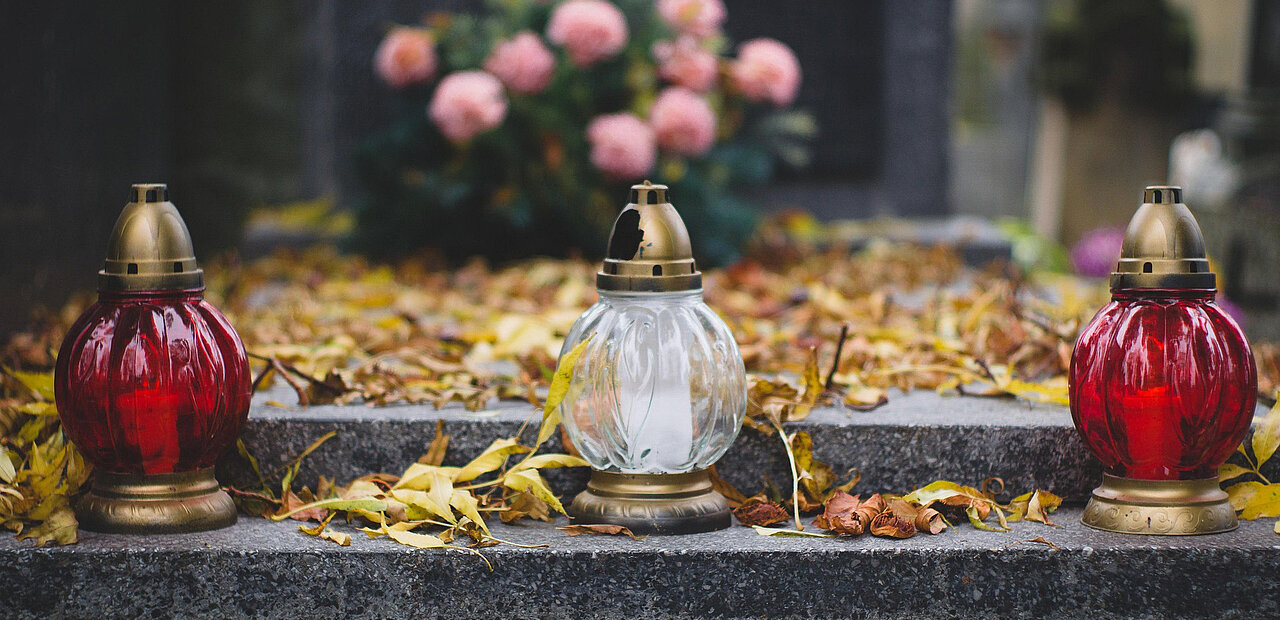 Kerzen am Grab als Zeichen der Liebe und der lebendigen Erinnerung.