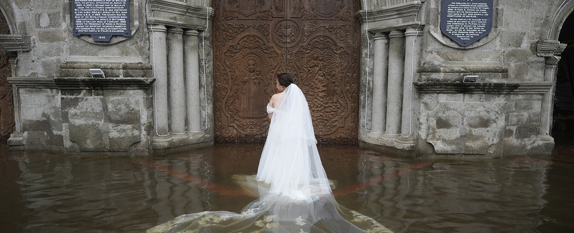 Auch religiöse Themen kommen bei den World Press Photos immer wieder vor. So wie die Fotostory von Aaron Favila: Die Braut Jamaica Aguilar bereitet sich darauf vor, für ihre Hochzeit die überflutete Barasoain-Kirche zu betreten. Die Barasoain-Kirche, ein nationales Kulturdenkmal, befindet sich in einer Region, in der nahezu 75 Prozent der Bevölkerung von Überschwemmungsrisiken betroffen sind. Malolos, Provinz Bulacan, Philippinen, 22. Juli 2025.