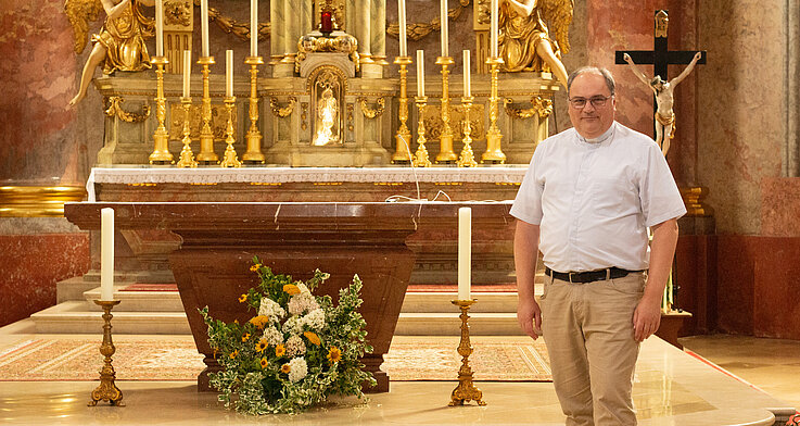 Pfarrer Andreas Kaiser  vor dem Altar in der Pfarrkirche Stockerau. Er selbst habe keine Lieblingskirche im Pfarrverband, erzählt er. 