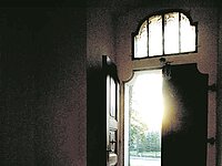 Eine offene Holztür führ hinaus auf die Straße