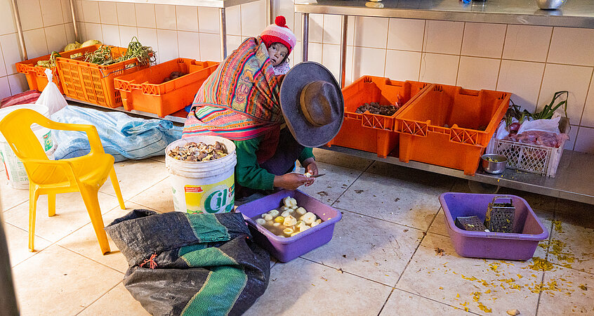 Eine Dame schneidet Kartoffel in Peru