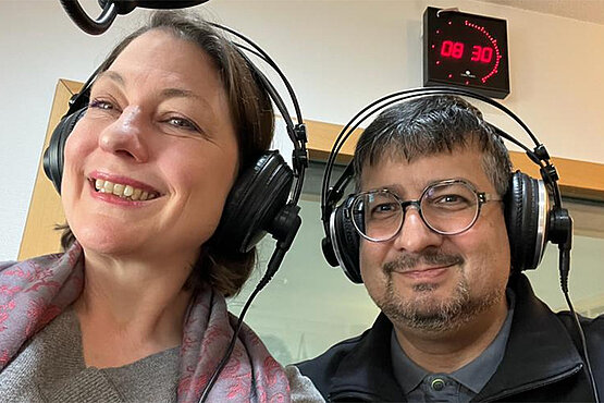 Frau und Mann mit Kopfhörern im Radiostudio