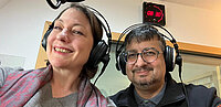 Frau und Mann mit Kopfhörern im Radiostudio