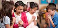 Kinder sitzen und beten