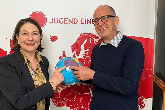 Sophie Lauringer mit Bruder Lothar bei Jugend Eine Welt, auf einem Globus auf Westafrika zeigend.