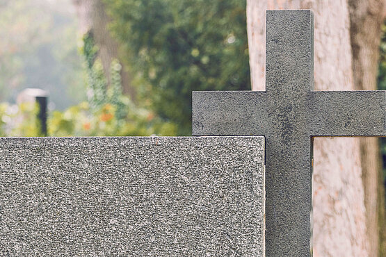 Leerer Grabstein und Kreuz