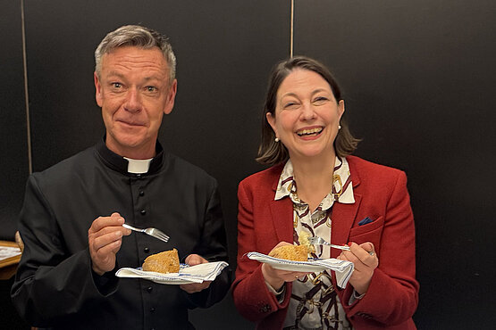 Jürgen Pfaffinger und Sophie Lauringer bei der Podcast-Aufnahme. Sie essen Kuchen.