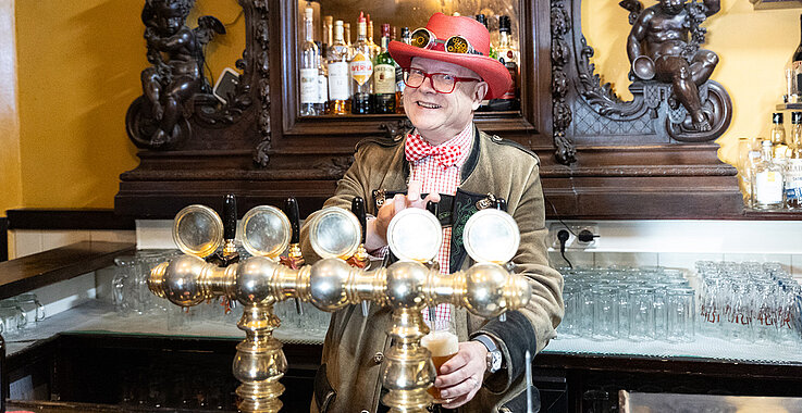 Conrad Seidl schenkt sich ein Glas Bier ein