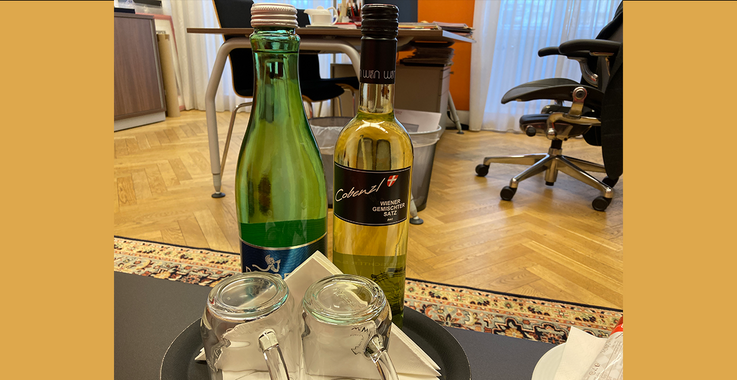 Eine Flasche „Gemischter Satz" und eine Mineral-Flasche auf einem Tablett.